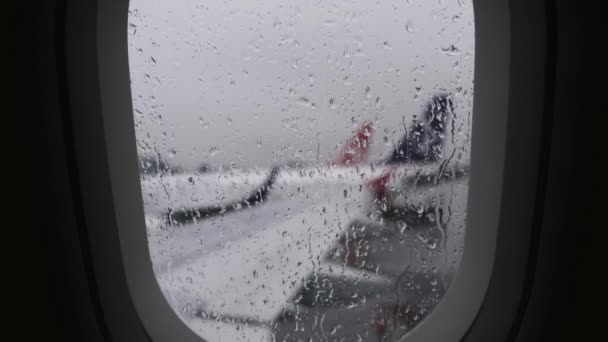 Vista desde la portilla del avión en un día lluvioso — Vídeo de stock