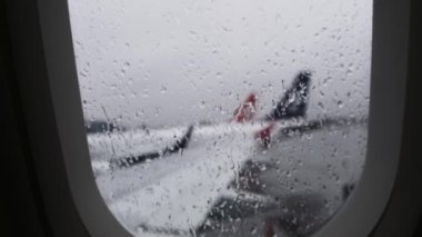 Yağmurlu bir günde uçağın lombozundan görüntü. Kapat.