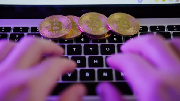 Gouden munt Bitcoin op toetsenbord, handen op het toetsenbord type tekst Crypto valuta cursus. — Stockvideo