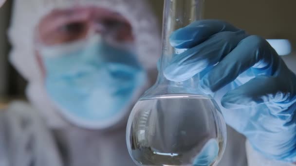 Assistant de laboratoire scientifique analyse en laboratoire les substances chimiques pour les réactions en fiole. Gros plan — Video
