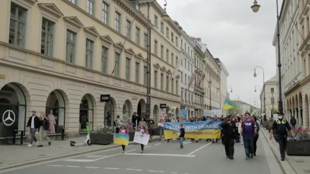 Ukrainian women and men protest on the streets of Munchen people with placards, flags Europe, Deutschland Munchen, May 2022 — стокове відео