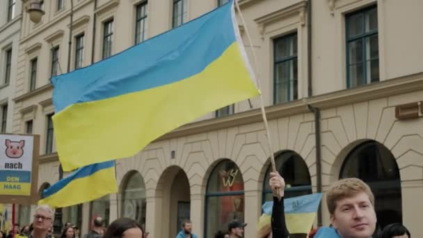 Ukrainian people protest on the streets of Munchen opposition the war and against the Russian leader Putin. people with placards, flags Europe, Deutschland Munchen, May 2022 — Vídeo de Stock