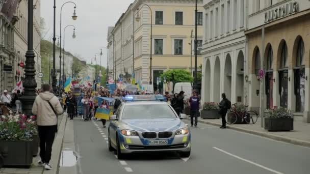 Ukrainian people protest on the streets of Munchen against the war and against the Russian leader Putin. people with placards, flags Europe, Deutschland Munchen, May 2022 — ストック動画