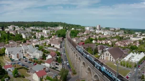 Treno passeggeri che passa sopra il ponte del viadotto sul paesaggio urbano. — Video Stock