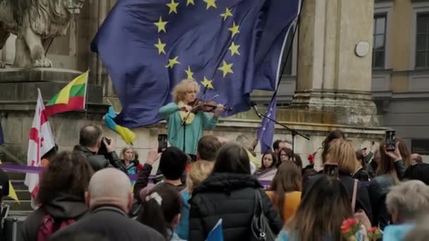 Vew of Ukrainian people protesteren in de straten van Munchen tegen de oorlog en tegen de Russische leider Poetin. mensen met borden, vlaggen Europa, Deutschland Munchen, mei 2022 — Stockvideo