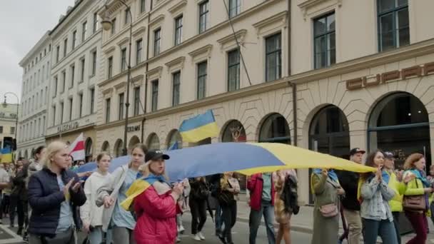 Ukraińcy protestują na ulicach przeciwko wojnie. Ludzie z dużymi flagami Ukraina, Niemcy Monachium, maj 2022 — Wideo stockowe