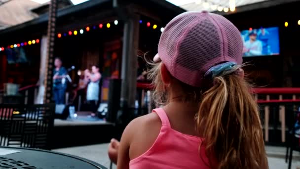 Kleines Mädchen beobachtet und jubelt im Publikum während des Konzerts. Nahaufnahme — Stockvideo