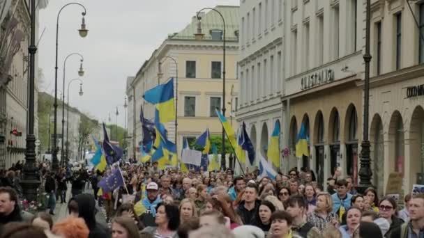 Ukraińcy protestują na ulicach Munczen przeciwko wojnie i przeciwko Rosjanom. osoby z plakatami, flagami Europy, Deutschland Munchen, maj 2022 r. Szeroki strzał. — Wideo stockowe