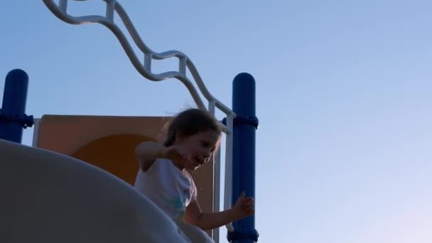 Молодая Девушка Смеется Наслаждается Игровой Площадкой Парке Скользит Горке Высококачественные — стоковое видео