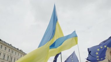 Ukraynalılar Münih sokaklarında savaşı protesto ediyorlar. Ukrayna bayrakları. Yüksek kalite 4k görüntü