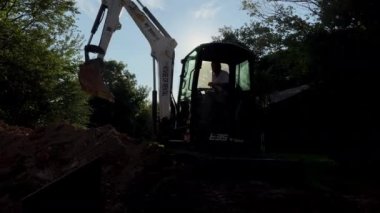 An excavator digs a trench. Close up shot. Naperville IL. 20 Aug 2022. High quality 4k footage