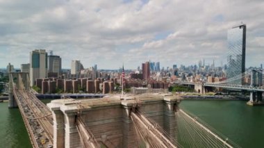 AERIAL Flight over Brooklyn Bridge with American flag and East River view over Manhattan New York City Skyline . High quality 4k footage