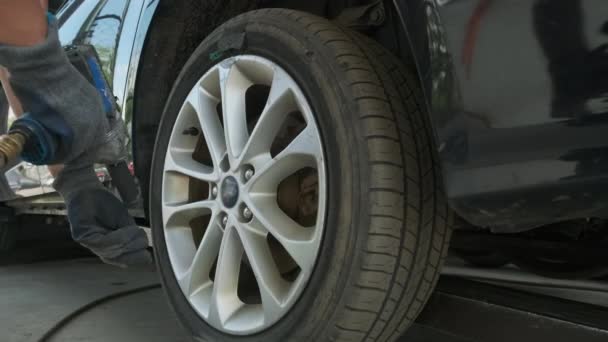 Car Mechanic Unscrewing Car Wheel Lifted Automobile Repair Service Station — Vídeo de Stock