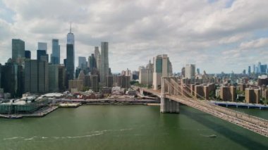 AERIAL Flight over Brooklyn Bridge with American flag and East River view over Manhattan New York City Skyline . High quality 4k footage
