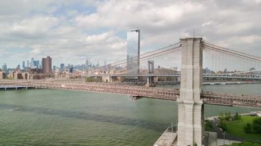 AERIAL Flight over Brooklyn Bridge with American flag and East River view over Manhattan New York City Skyline . High quality 4k footage
