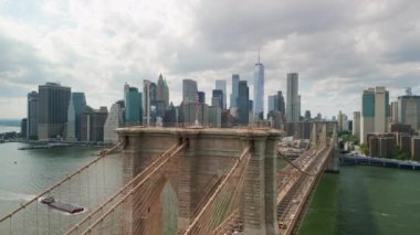 AERIAL Flight over Brooklyn Bridge with American flag and East River view over Manhattan New York City Skyline . High quality 4k footage