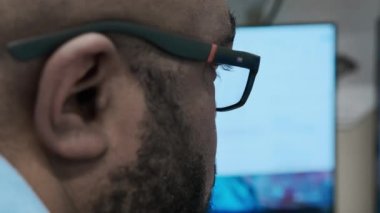 Yakışıklı Siyah Adam 'ın Gözlüklü Portresi Bilgisayarda Çalışıyor. Yüksek kalite 4k görüntü