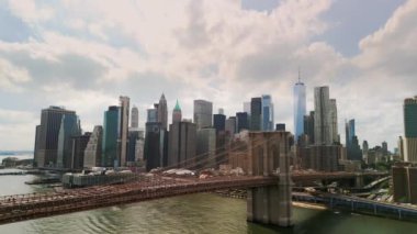 AERIAL Flight over Brooklyn Bridge with American flag and East River view over Manhattan New York City Skyline . High quality 4k footage