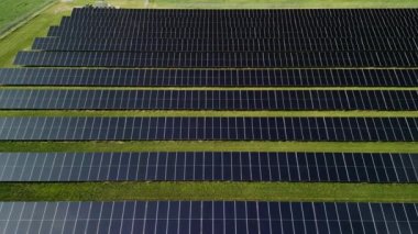 Güneş panellerinin inanılmaz günbatımı görüntüsü tarlalarda sıralanmış yeşil enerji manzarası elektrik ekolojisi. Yüksek kalite 4k görüntü