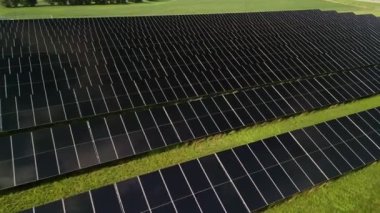 Güneş panellerinin inanılmaz günbatımı görüntüsü tarlalarda sıralanmış yeşil enerji manzarası elektrik ekolojisi. Yüksek kalite 4k görüntü