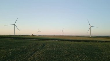 Rüzgâr türbinleri gün batımında buğday tarlasında duran bir rüzgar parkının havadan görüntüsü. - Evet. Yüksek kalite 4k görüntü