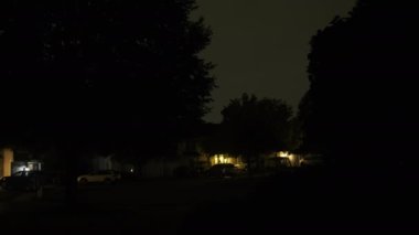 Gece vakti şiddetli bir fırtına, gürültülü gök gürültüsü ve şimşekle, bir banliyö mahallesi sokağı. Yüksek kalite 4k görüntü