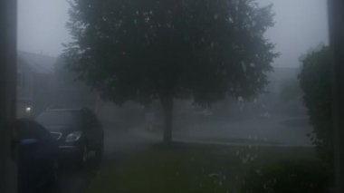 Şiddetli fırtına, gürültülü gök gürültüsü ve şimşekle, bir banliyö yerleşim yeri caddesi. Yüksek kalite 4k görüntü