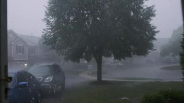 Şiddetli fırtına, gürültülü gök gürültüsü ve şimşekle, bir banliyö yerleşim yeri caddesi. Yüksek kalite 4k görüntü