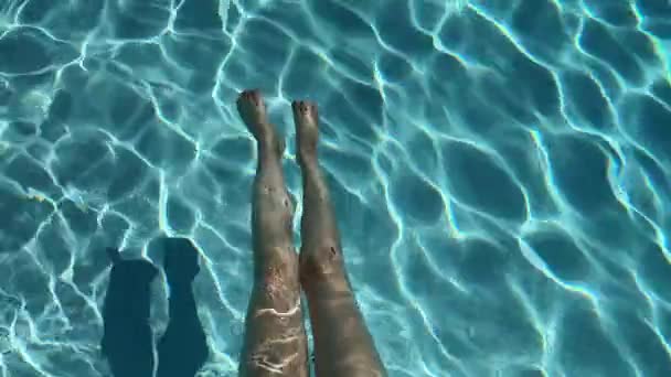 暑い夏の日にプールで青い水に対する女性の足 高品質4K映像 — ストック動画