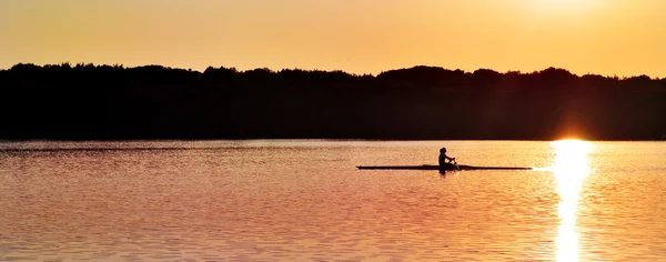 Canoa ao pôr do sol no lago — Fotografia de Stock