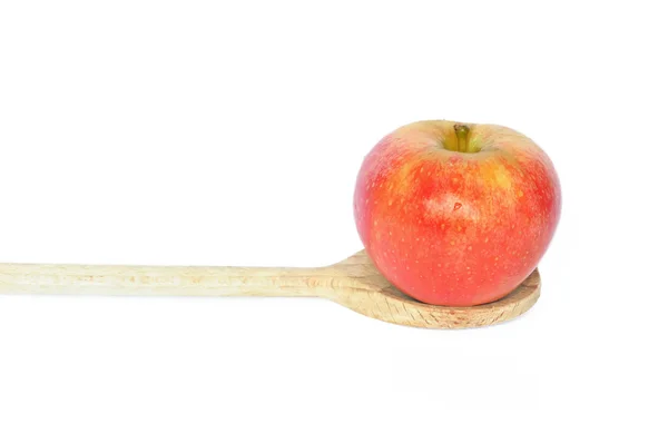 Red apple on wooden spoo — Stock Photo, Image