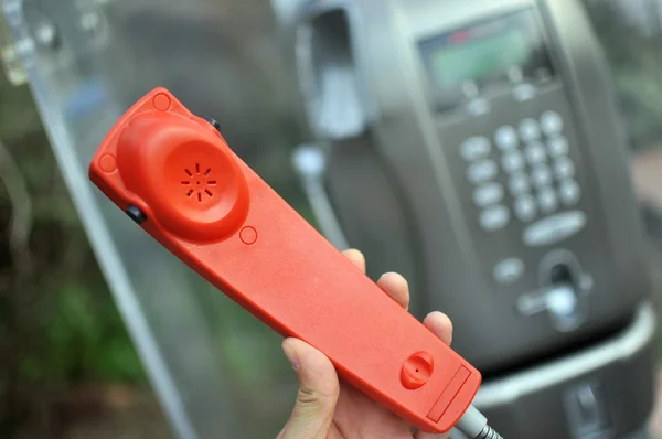 Rode hoorn van een openbare telefoon — Stockfoto