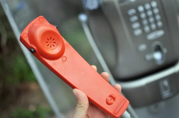 Rode hoorn van een openbare telefoon — Stockfoto