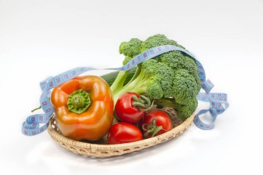 Beyaz arka planda sepette taze brokoli, salatalık, biber ve domates. Sağlıklı gıda konsepti. Vejetaryenlik ve vejetaryenlik