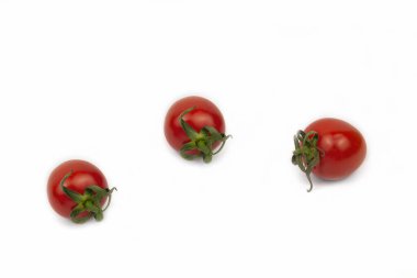 Üç kırmızı vişneli domates, beyaz üzerine izole edilmiş datterino tipi, kopyalama alanı. Taze vejetaryen yemeği.