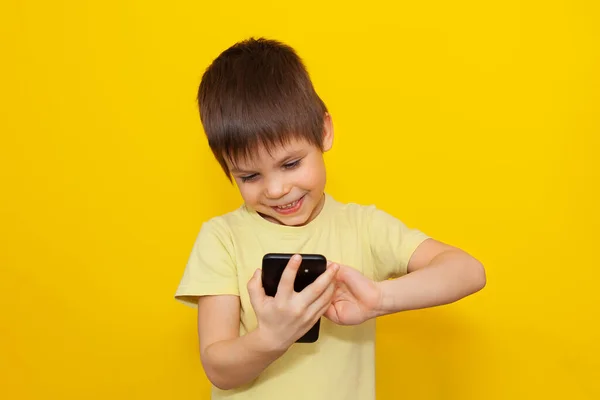 Küçük Çocuk Sarı Arka Planda Akıllı Telefondan Oyun Oynuyor Modern — Stok fotoğraf