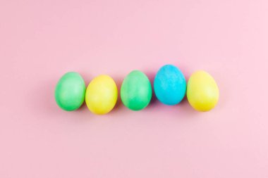 Paskalya pembesi kompozisyon. Pastel pembe arka planda Paskalya yumurtaları. Minimum Paskalya konsepti. Düz konum, üst görünüm, kopyalama alanı.