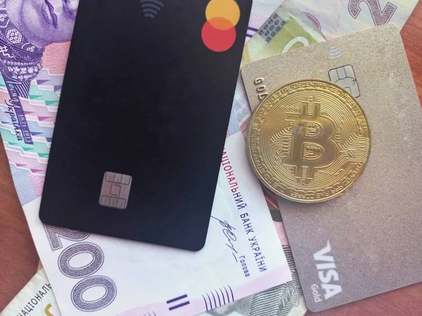 Kropyvnytskyy UKRAINE - March 19, 2022: Credit Card Master Card and new banknotes with a face value of 500, 200 and 100 hryvnia. Ukrainian money. Business concept.