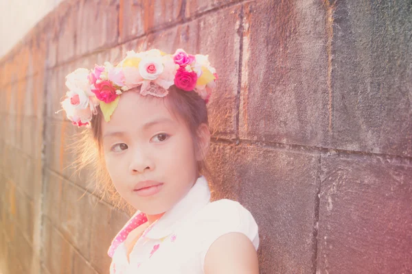 Hermosa niña con flores en la cabeza, textura vintage — Foto de Stock