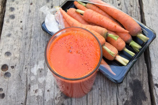 Стакан морковного сока и свежей моркови — стоковое фото