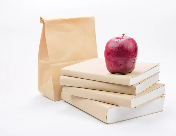 Mela fresca su pila di vecchi libri, isolata su bianco — Foto Stock