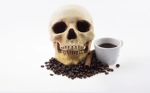 Calavera humana remojo y taza de café —  Fotos de Stock