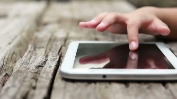 Pequeña chica asiática tocando la superficie del ordenador tableta pantalla táctil ipad — Vídeos de Stock