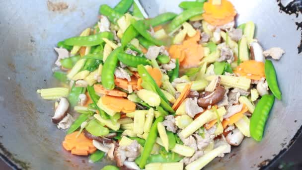 Remover las verduras fritas con cerdo en una sartén — Vídeos de Stock