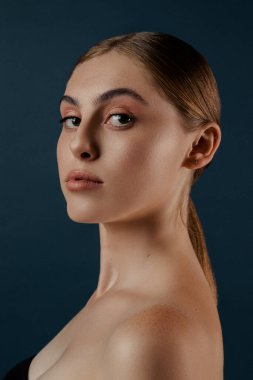 Genç bir kız, kusursuz ciltli bir kadın. Stüdyoda izole edilmiş bir kadın. Moda, doğal çıplak makyajlı ve uzun kirpikli güzellik mankeni portresi. Mavi katı arkaplan. 