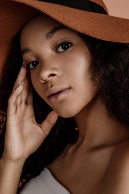 Close up portrait of sensual young female in hat. Clean skin. Healthy care. Portrait of beautiful african american in hat isolated. Studio shoot. Portrait of beauty girl model with natural make up