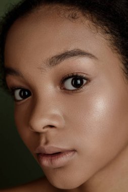 Beauty photo of young elegant African American woman with afro. Hands posing. Gentle portrait.  Fashion beauty close up portrait. Nude make-up. Studio photoshoot. Female model. Beautiful girl