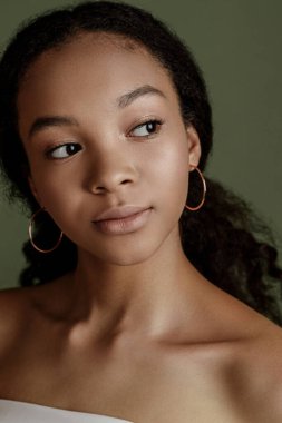Beauty photo of young elegant African American woman with afro. Hands posing. Gentle portrait.  Fashion beauty close up portrait. Nude make-up. Studio photoshoot. Female model. Beautiful girl