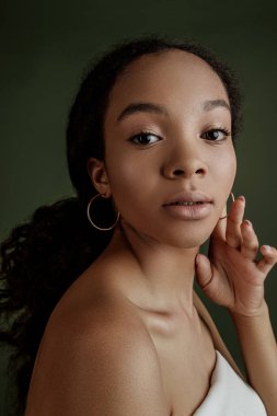 Beauty photo of young elegant African American woman with afro. Hands poses. Gentle portrait.  Fashion beauty close up portrait. Nude make-up. Studio photoshoot. Female model. Beautiful girl