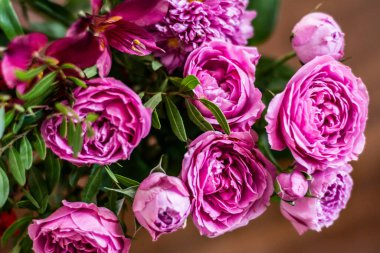 Delicate blossoming pink, white  flowers, blooming roses festive background, flower bouquet pastel image, soft petal. On dark grey rustic wooden background. Roses flowers background